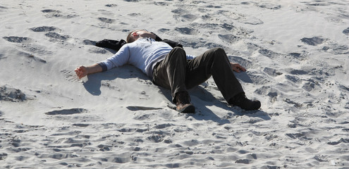 Mann entspannt und sonnt sich am Strand