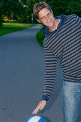 Happy young guy playing basketball