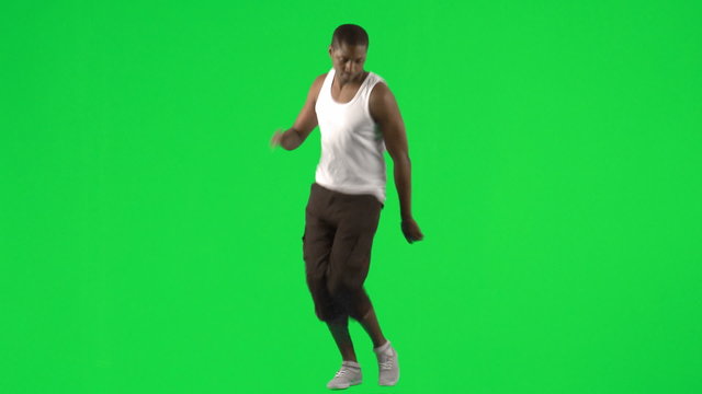 Young man dancing with a green background