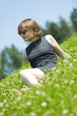 Fototapeta premium Junge Frau sitzt in der Wiese