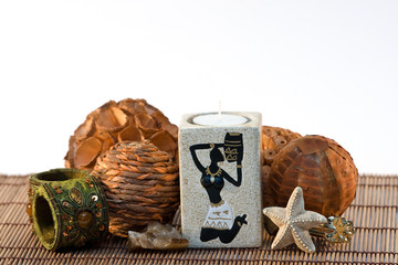 Indian candlestick on mat with decoration and bracelet isolated