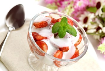 Glass of plain yogurt with fresh strawberries and mint