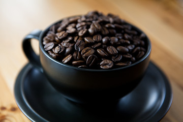 Coffee beans in a black coffee cup