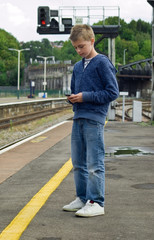 youth texting at railway station