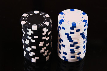 white and black casino chips on black background