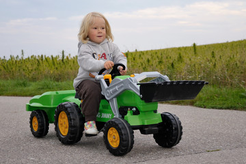 Junge auf Trettraktor