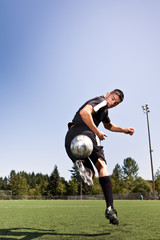 Hispanic soccer or football player kicking a ball