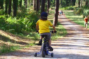 Petit garçon en vélo dans la forêt