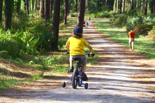 petit garçon en vélo dans la forêt