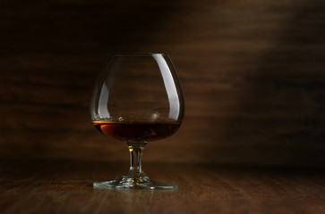 Cognac in the big glass on a dark background