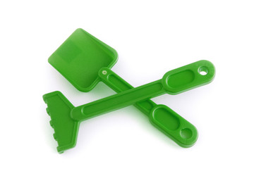 Râteau et pelle verts de plage pour enfant sur fond blanc