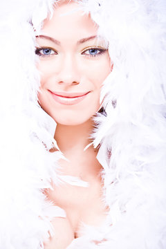 smiling young woman with white downy boa over her head