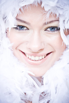 portrait of smiling young woman with white downy boa