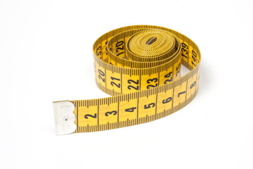 A coiled yellow measuring tape isolated on white