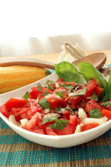 organic tomato salad in bowl with onion and basil
