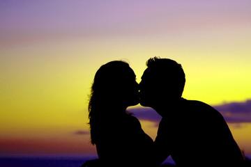 Silhouette of couple kissing at sunset