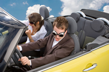Young couple having fun driving a MINI convertible