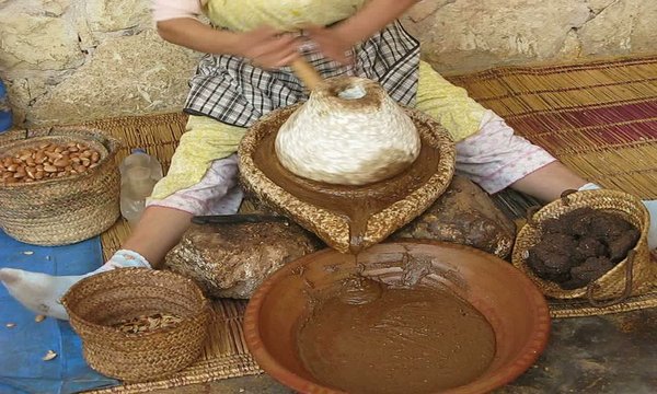 MUJER MOLIENDO EL FRUTO DEL ARBOL DE ARGAN