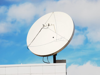 Satellite dish on the modern building roof corner
