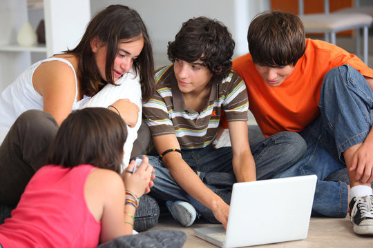 jeunes gar&ccedil;ons et filles assis devant un ordinateur portable