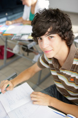 Portrait d'un jeune garçon souriant assis en salle de cours