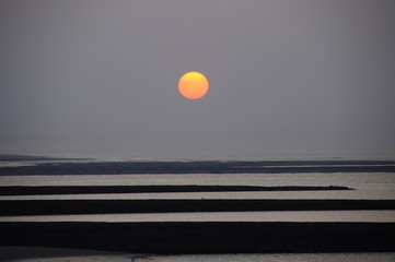 Sonnenuntergang bei Ebbe über den Buhnen