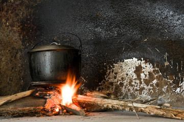 A soot blackened iron pot over an open fire in a rural kitchen