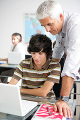 jeune garçon devant un ordinateur portable près d'un homme