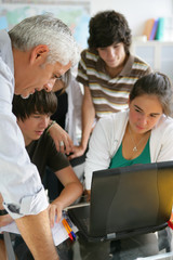 Adolescents devant un ordinateur portable près d'un homme