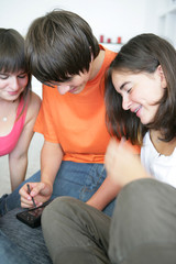 Adolescents assis par terre avec une console portable