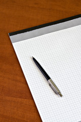 close-up of notebook and a black pen