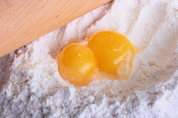 Two yolks lie on a flour
