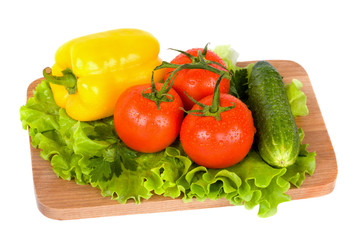 Fresh colorful vegetables on wooden board isolated on white