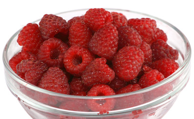 Close up of ripe raspberries in a glass bowl isolated on white