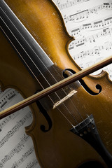 alte violine und bogen auf notenblättern