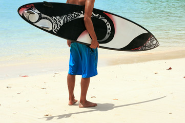 Surfer on beach with funky arty surfboard