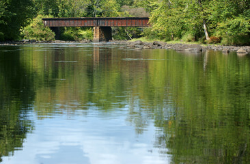 Fototapeta na wymiar Peaceful river with railroad bridge