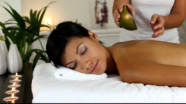 Jeune femme recevant un massage aux huiles essentielles