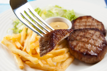 Grilled meat and, fries and  vegetable salad