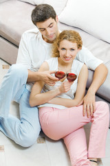 Young couple celebrating with red wine at home