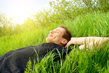 young man relax in spring grass