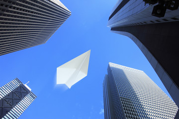 Obraz na płótnie Canvas 紙飛行機と高層ビル