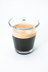 Espresso in einer Glastasse neben Mobiltelefon