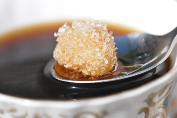 Cup of coffee and dissolving sugar lump