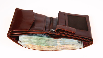 A brown wallet full of money isolated on a white background