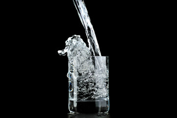 Water in glass isolated on black background