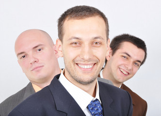 Group of young businessmen together on light background
