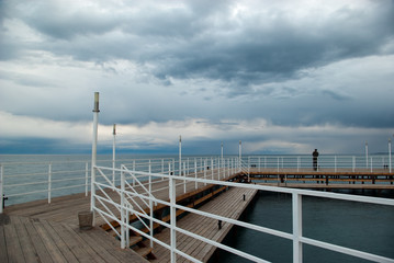Wooden quay on the water with blurred silhouette of a man