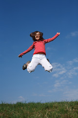Fototapeta na wymiar Girl jumping, running against blue sky