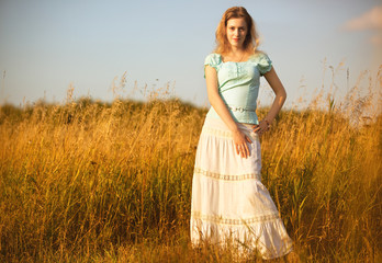 Fototapeta na wymiar Young woman on a summer field